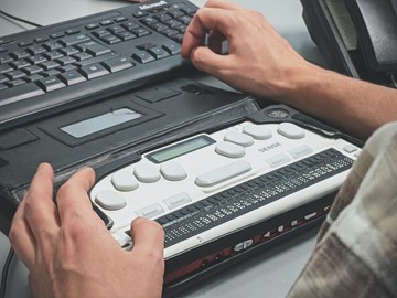 Blind person using a braille screen reader.