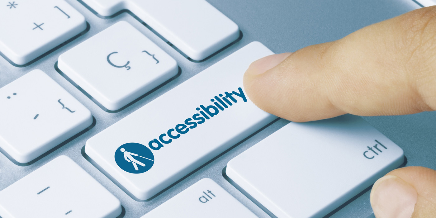 A finger hovers over a keyboard about to press a button labeled “accessibility”