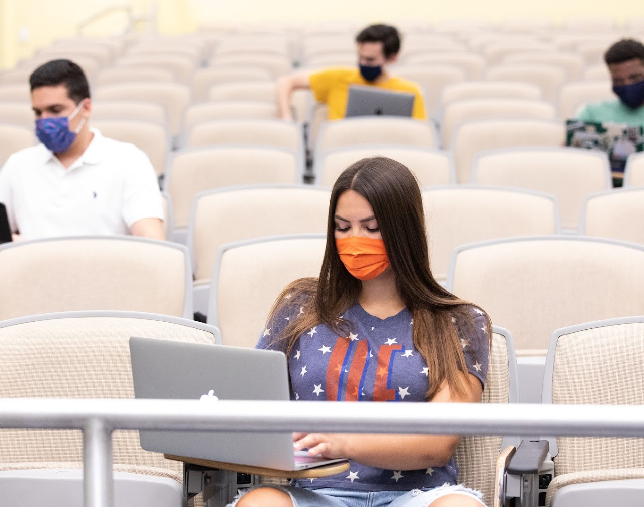 students in large classroom on laptops